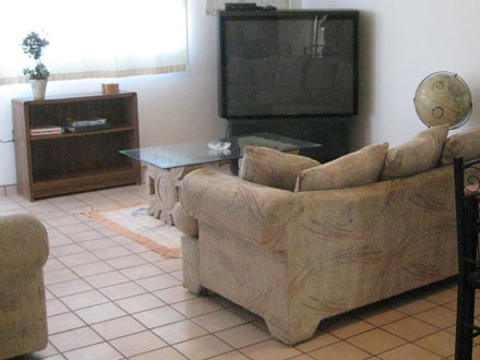 A large, airy furnished livingroom
connects to a deck,
accessed also by the bedroom